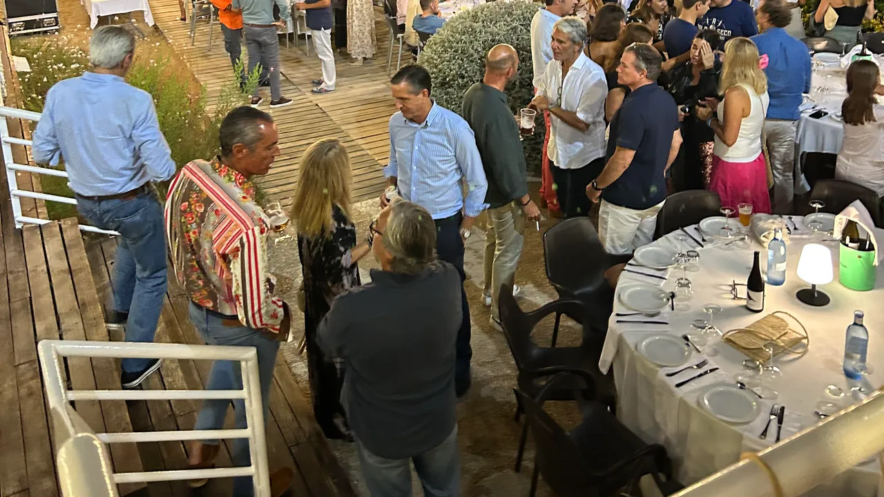 Cena de clausura 2022 al aire libre, con mesa larga y asistentes en la velada nocturna.